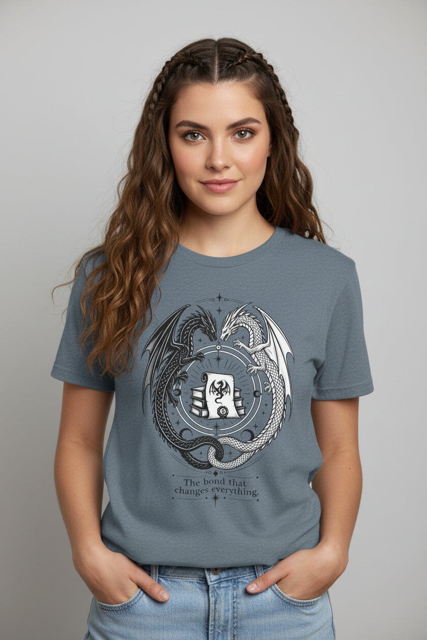 A heather slate blue short-sleeve t-shirt with a detailed graphic of two dragons wrapping around a shield and the motto 'The blood is the truth, changes everything.' on a plain white background.