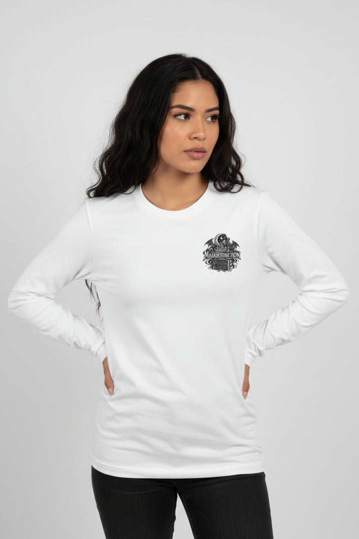 A white long-sleeve crewneck t-shirt featuring a black graphic print on the left chest with a skull, wings, and the word &