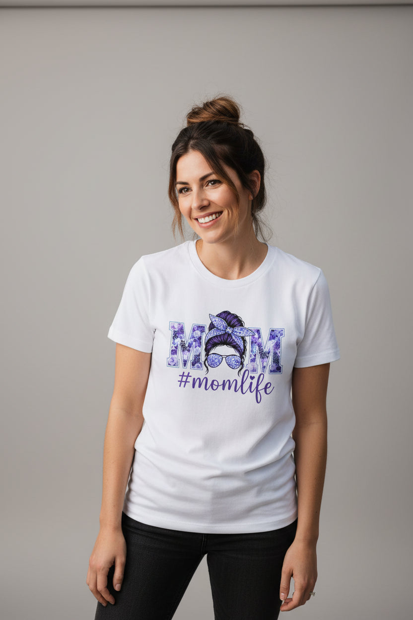 Woman wearing a white t-shirt with '#momlife' design outdoors
