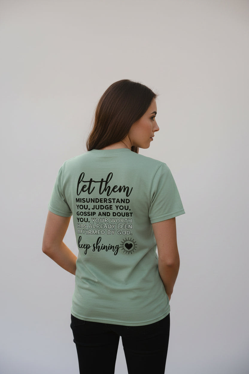 Light green t-shirt with motivational quote on the back against a white background